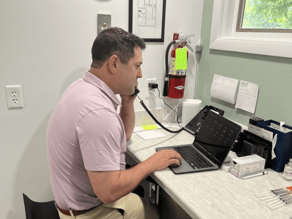 Person talking on the phone and working on laptop simultaneously Person talking on the phone and working on laptop simultaneously